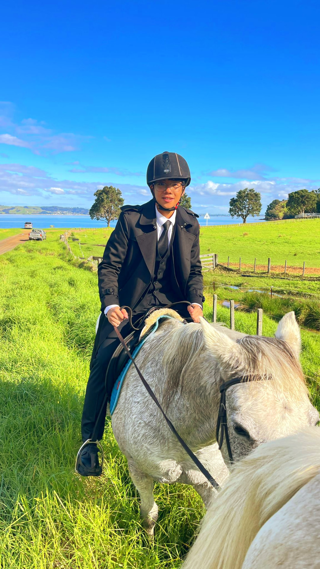 Alumnus horse riding in the New Zealand countryside during a weekend activity