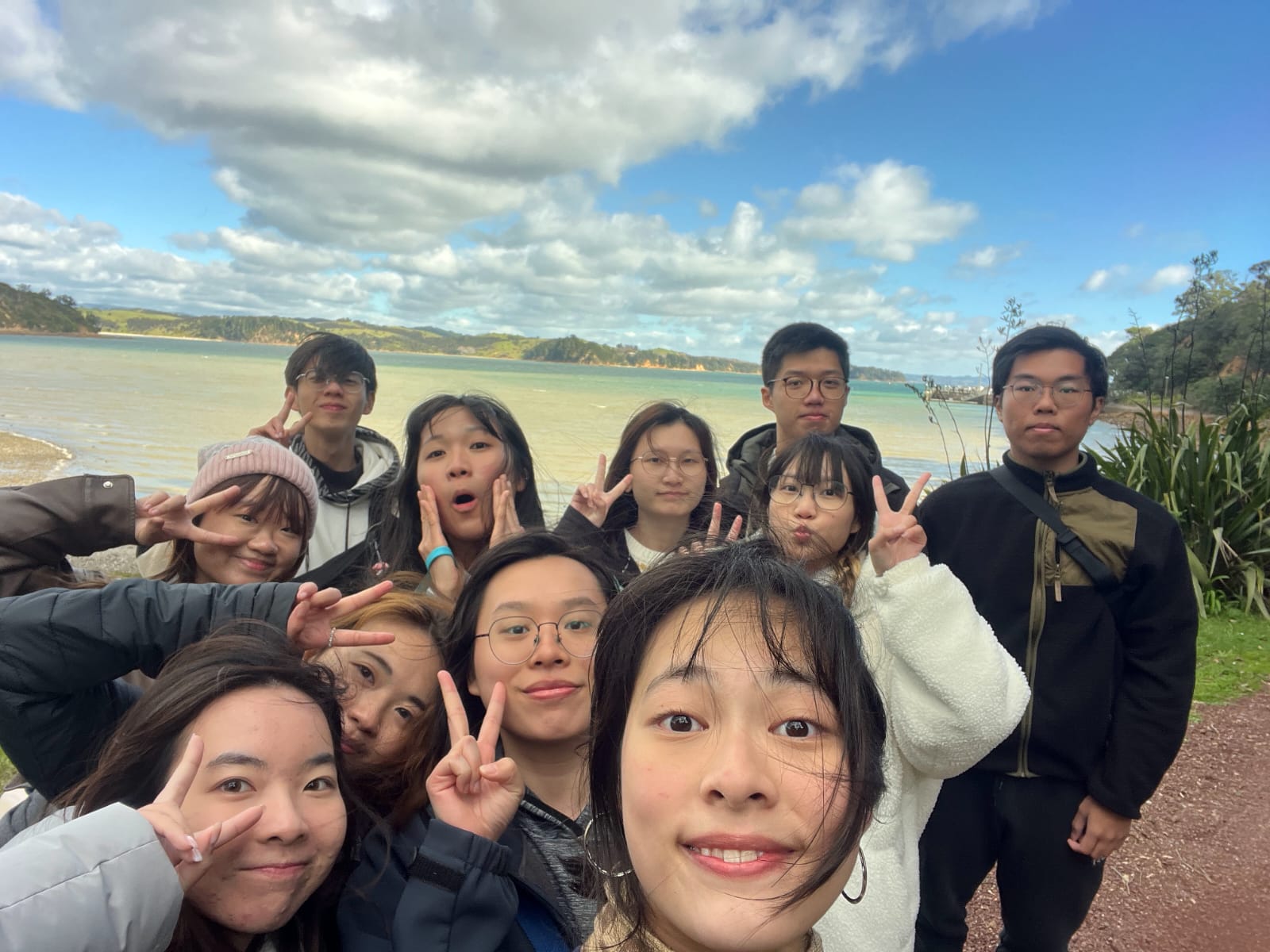 Intern cohort photographed at a coastal bay near Auckland, New Zealand