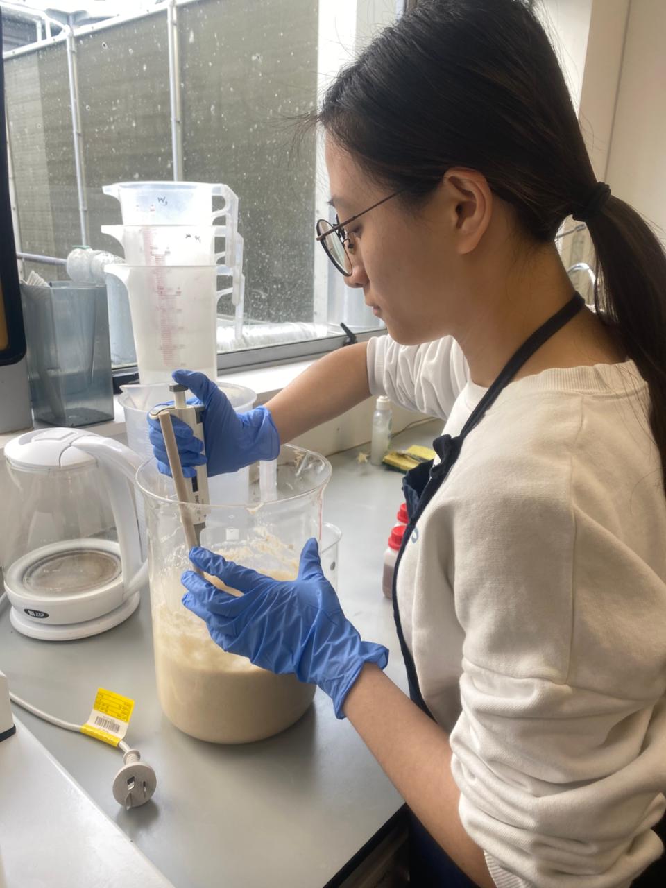 Alumna working with lab equipment during a science internship placement