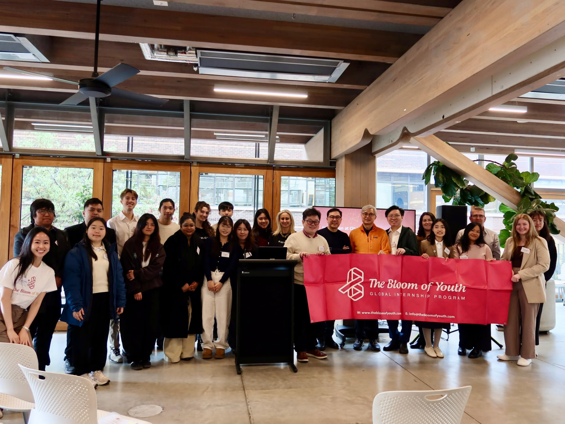 Bloom of Youth team and students with the Global Internship Program banner at an RMIT presentation
